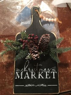 a christmas market sign with pine cones and berries