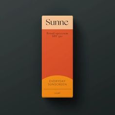 an orange and yellow box of sunscreen on a black surface with the words, sunne