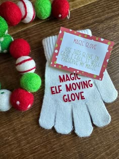 two white gloves with red and green pom - poms next to each other