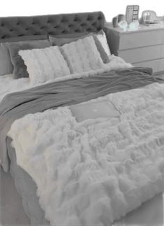 the bed is made with white fluffy blankets