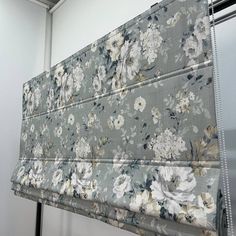 a flowered curtain hanging on the side of a wall next to a metal door