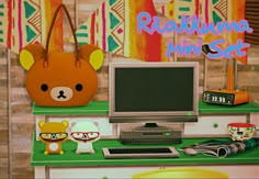 a computer monitor sitting on top of a desk next to a teddy bear bag and other items