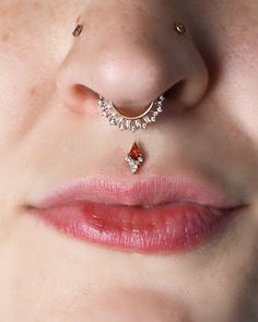 a woman's nose with an orange and white jeweled nose piece attached to it