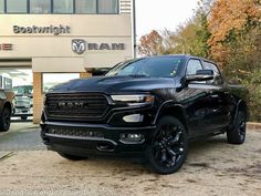 a black ram truck parked in front of a building