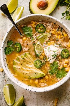 a white bowl filled with mexican chicken soup and garnished with avocado