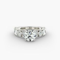 a three stone engagement ring with diamonds on the band and side stones in white gold