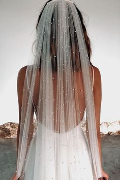 the back of a woman's wedding dress is shown with white stars on it