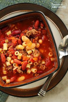 a bowl of chili macaroni and cheese soup on a plate with a spoon