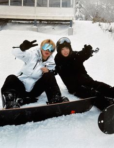 two snowboarders pose for a photo in the snow