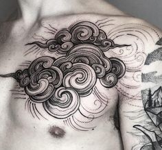 a man's chest is covered with black ink and has an intricate cloud tattoo on it