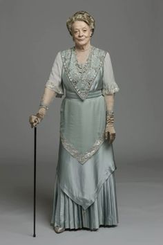 an older woman wearing a dress and holding a cane