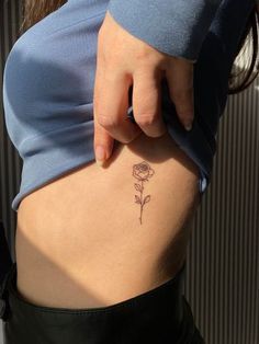 a woman with a rose tattoo on her lower back and the bottom part of her stomach