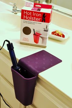 a purple cup holder on the counter in front of a sink