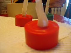 two toothbrushes sitting on top of a red cup next to each other at a table