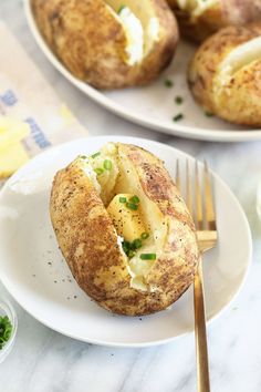 two plates filled with baked potatoes on top of a table