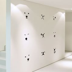 there are many panda faces on the wall in this room, and one is black