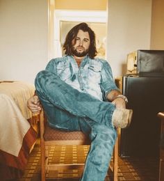 a man sitting in a chair with his legs crossed