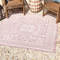 an outdoor area with chairs and rugs on the ground