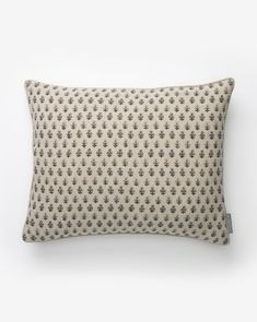 a beige and black patterned pillow on a white background with an arrow pattern in the middle