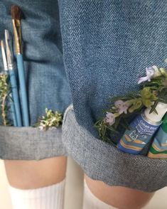 the legs of a person wearing white socks with flowers in their pockets and some toothbrushes sticking out of them