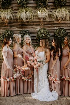 the bride and her bridesmaids are all dressed in long dresses with flower bouquets