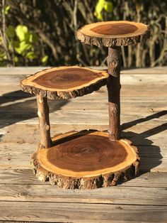 two wooden tables sitting on top of a wooden floor next to trees in the background