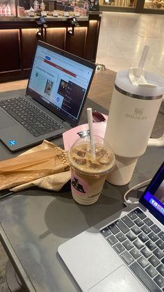 an open laptop computer sitting on top of a table next to a cup of coffee