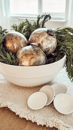 a white bowl filled with ornaments on top of a table