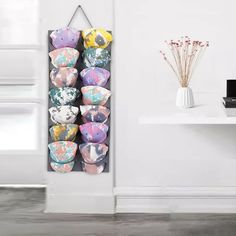 a wall mounted display case filled with lots of colorful bowls next to a white table