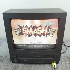 an old television with the word smash on it's screen and wires plugged in