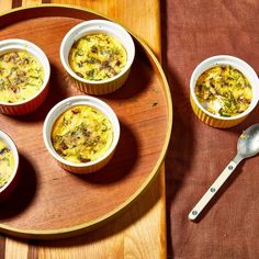 four cups of food on a wooden tray