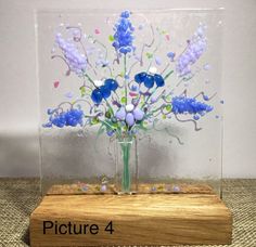 a glass vase with blue flowers in it