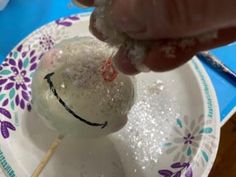 a person is dipping some kind of food on a stick with sugar and sprinkles