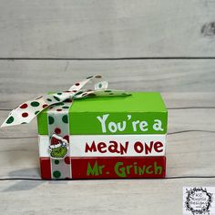 a green box with a red and white ribbon on it that says, you're a mean one mr grin