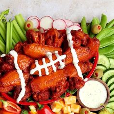 a football shaped platter with meats, veggies and dip