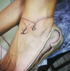 a woman's foot with the word love on it and a dotted line tattoo