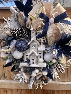 a wreath that is hanging on the side of a wooden door with decorations around it