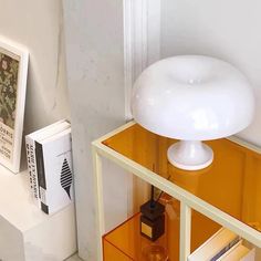 a white lamp sitting on top of a wooden shelf