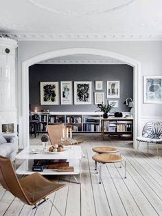 a living room filled with furniture and pictures on the wall