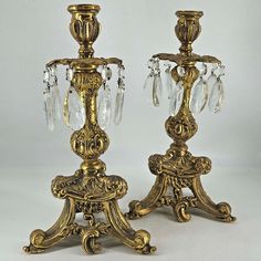 two golden candlesticks with crystal beads on them