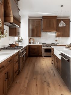 a large kitchen with wooden cabinets and white counter tops, along with stainless steel appliances