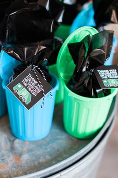 plastic trash cans with black and green bags in them