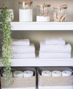 the shelves are filled with white towels and baskets