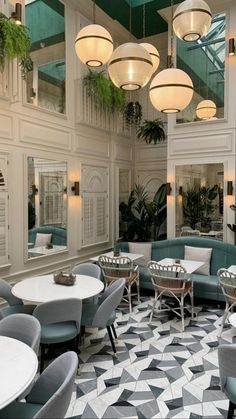 a restaurant with tables and chairs in the center, surrounded by potted plants on either side