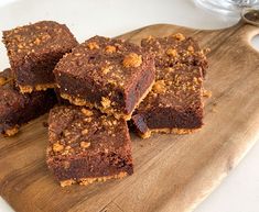 several pieces of brownie sitting on top of a wooden cutting board