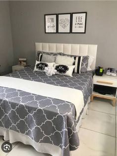 a white and gray bedroom with pictures on the wall