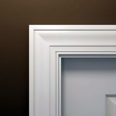 an open white frame on the wall next to a black and white cat sitting in it