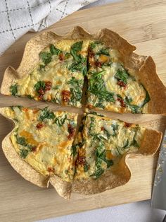 a pizza with spinach and cheese cut into four slices