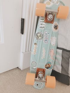 a skateboard with many stickers on it sitting in front of a white door