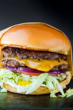 a cheeseburger with lettuce, onion and tomato